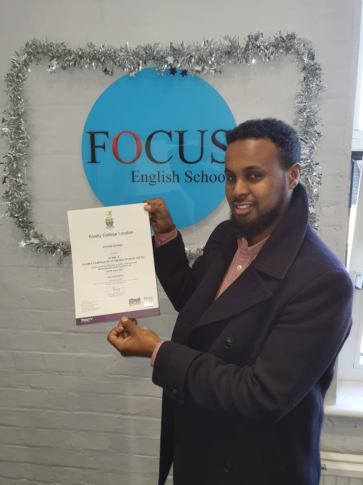 Happy student at Focus English School after passing his Trinity exam.
