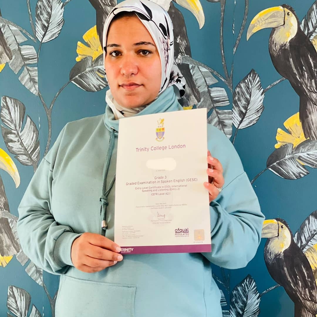 Focus English student proudly holding her Trinity College London certificate.