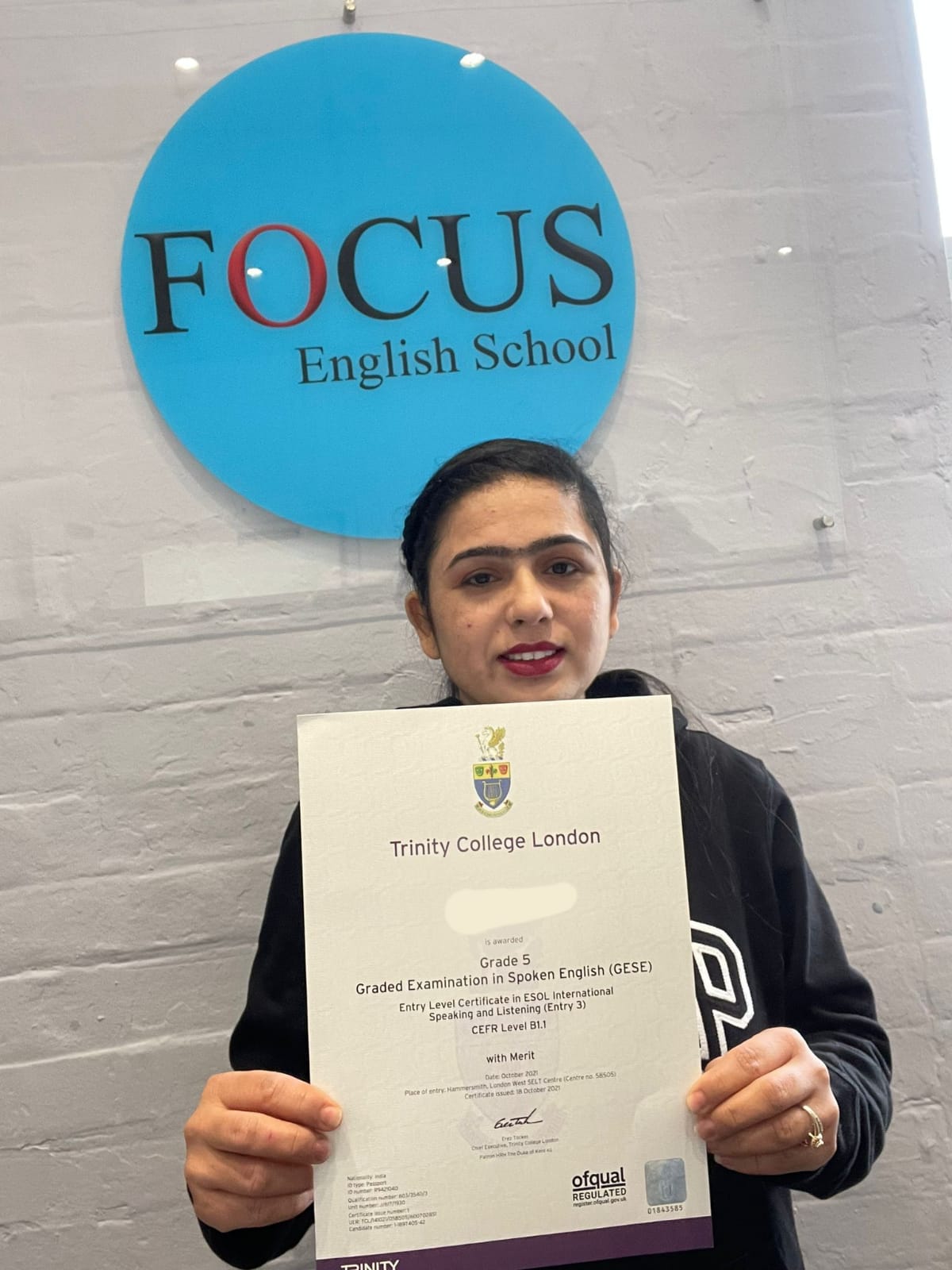 A student from Focus English with her passing certificate from Trinity College London.